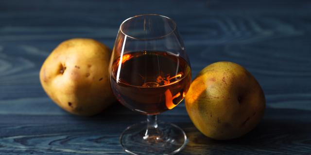 traditional fruit brandy and pears on a vintage grunge wooden background