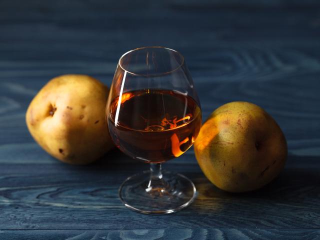 traditional fruit brandy and pears on a vintage grunge wooden background