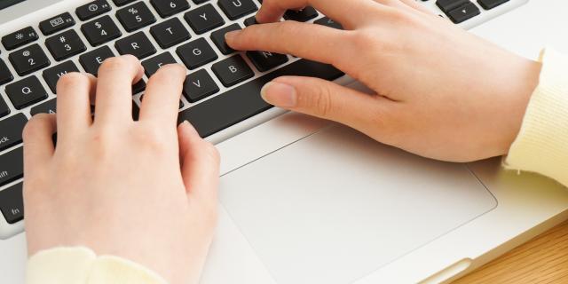 Young woman typing with laptop