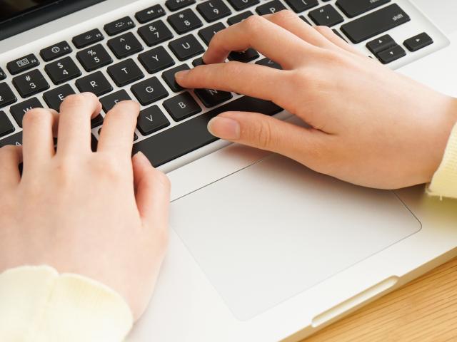 Young woman typing with laptop