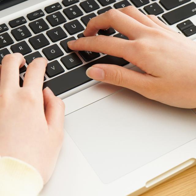 Young woman typing with laptop