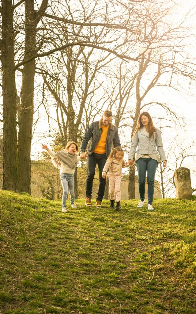 Happy parents playing with their daughters in the park. Space for copy.