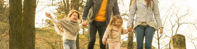 Happy parents playing with their daughters in the park. Space for copy.