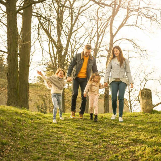 Happy parents playing with their daughters in the park. Space for copy.