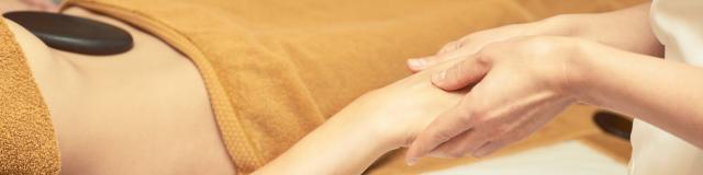 body arm stone massage. Hot rock masseur. Girl at salon with doctor hands. Relax spa resort.