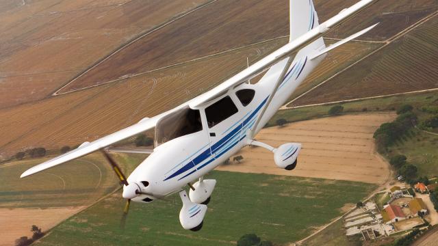 Small airplane flying over farm