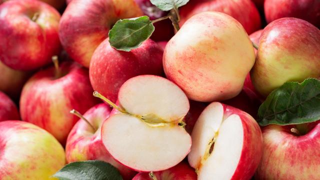 fresh apples with leaves as background, top view