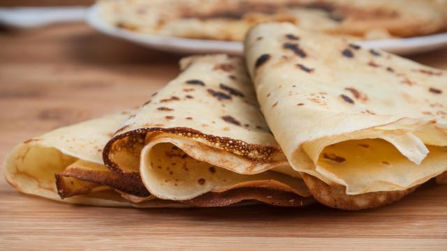 crêpes dans une assiette sur fond de planche à découper en bambou