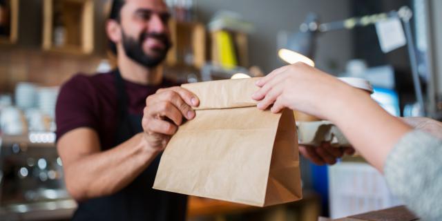 small business, people and service concept - man or bartender serving customer at coffee shop