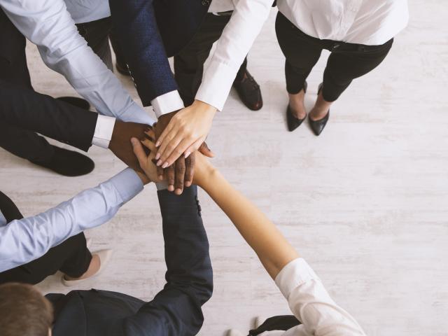 Business collaboration. United corporate team stacked hands together, top view, panorama with copy space