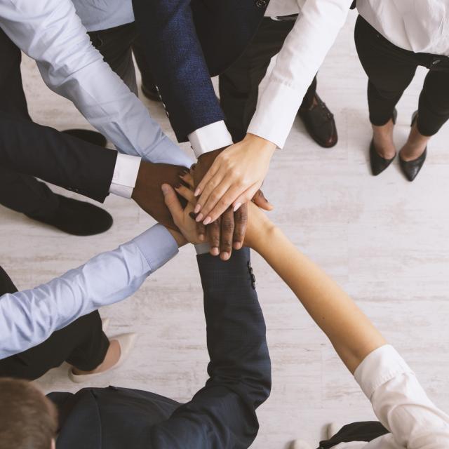 Business collaboration. United corporate team stacked hands together, top view, panorama with copy space