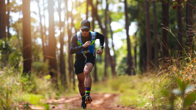 A man Runner of Trail . and athlete's feet wearing sports shoes for trail running in the forest