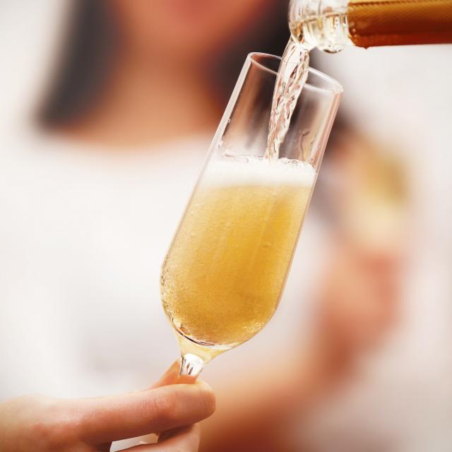 Pouring champagne into glass at hen-party, close up